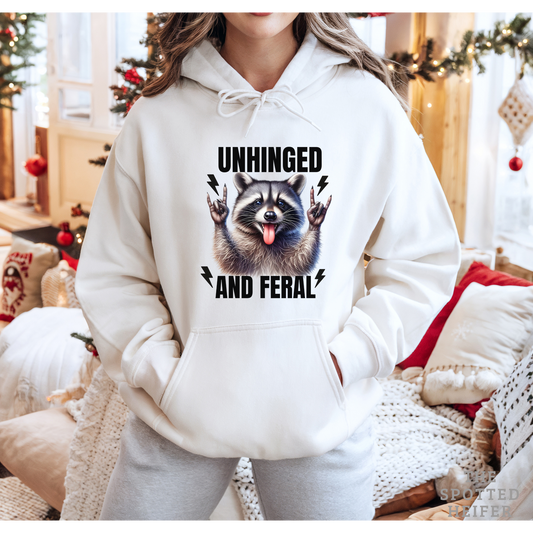 Person wearing a white hoodie with a raccoon graphic and text in a festive indoor setting.