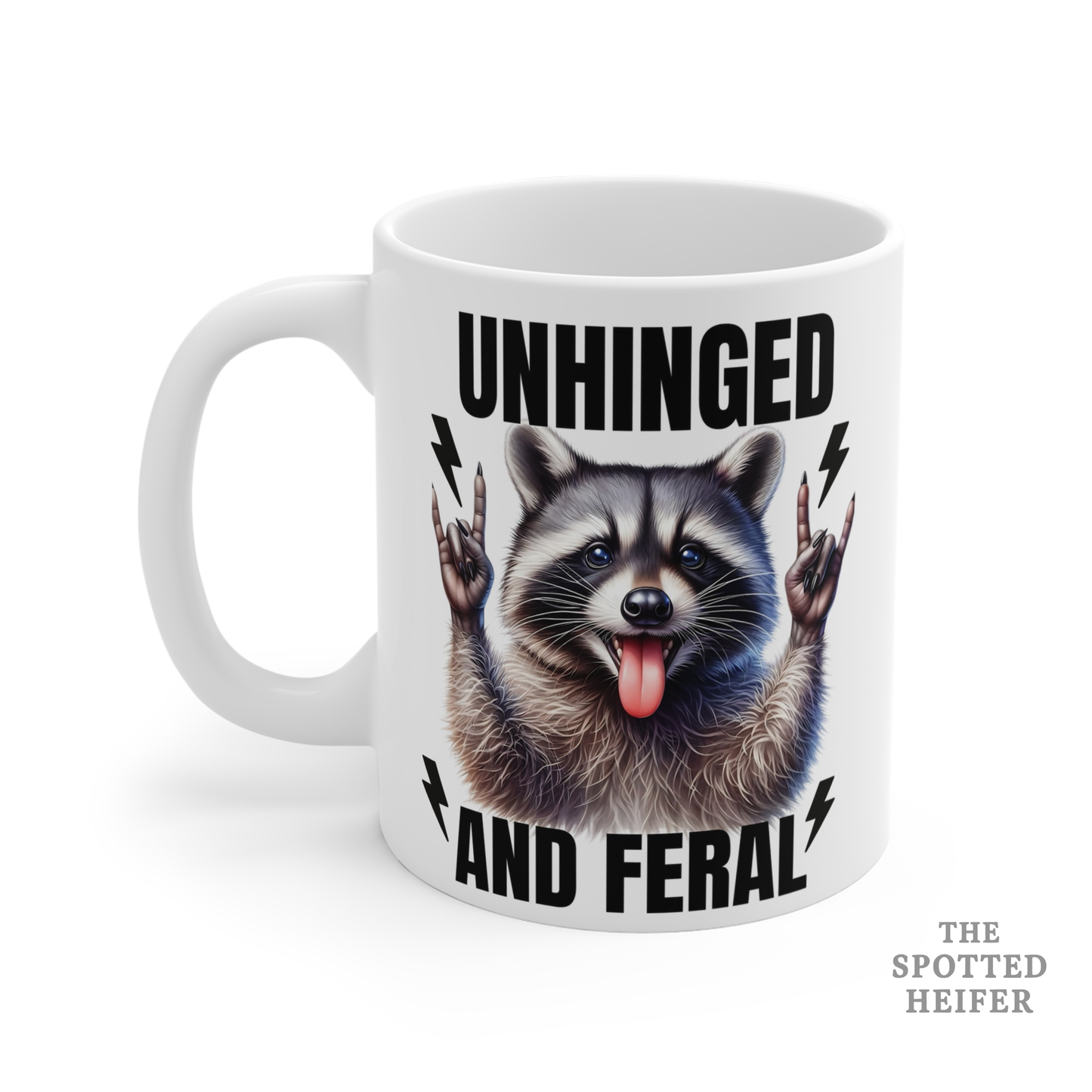 Left side of a white Unhinged and Feral raccoon mug showing the handle and part of the black distressed lettering, funny animal-themed coffee mug.