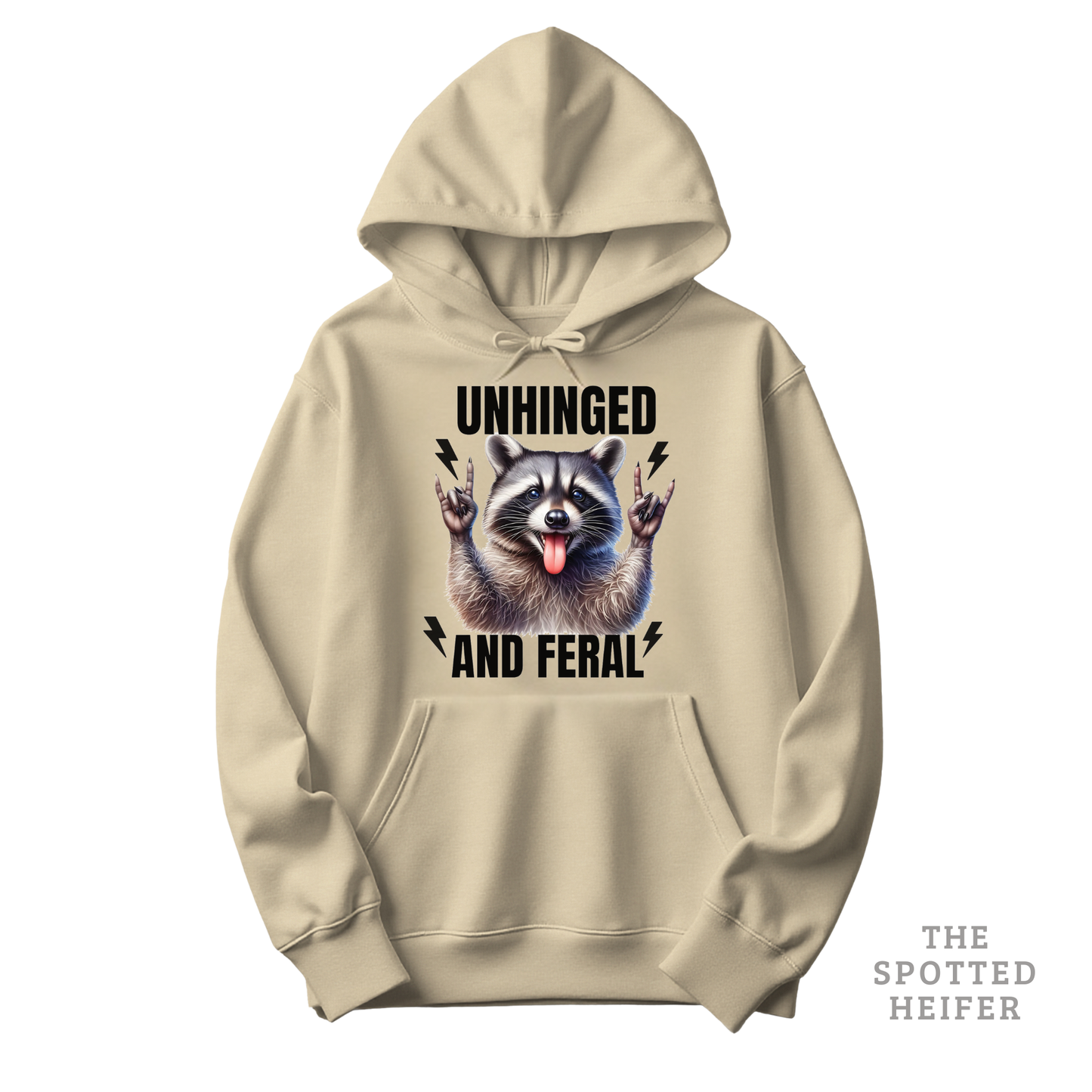 Sand Gildan 18500 hoodie featuring “Unhinged and Feral” text with a raccoon graphic on the front – funny country hoodie by The Spotted Heifer.