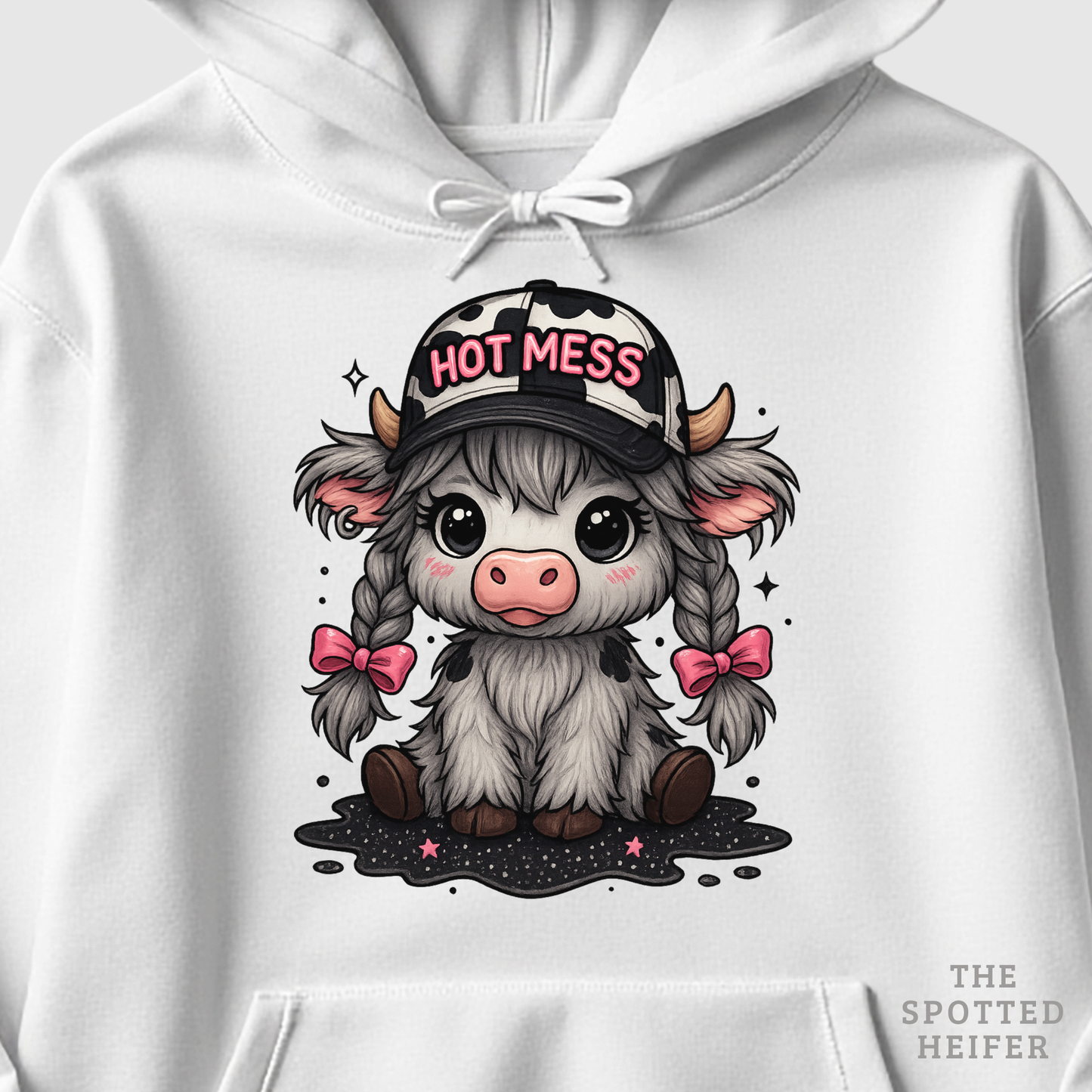 Close-up of Hot Mess cow design with pink bows, braids, and cow-print hat on white hoodie.